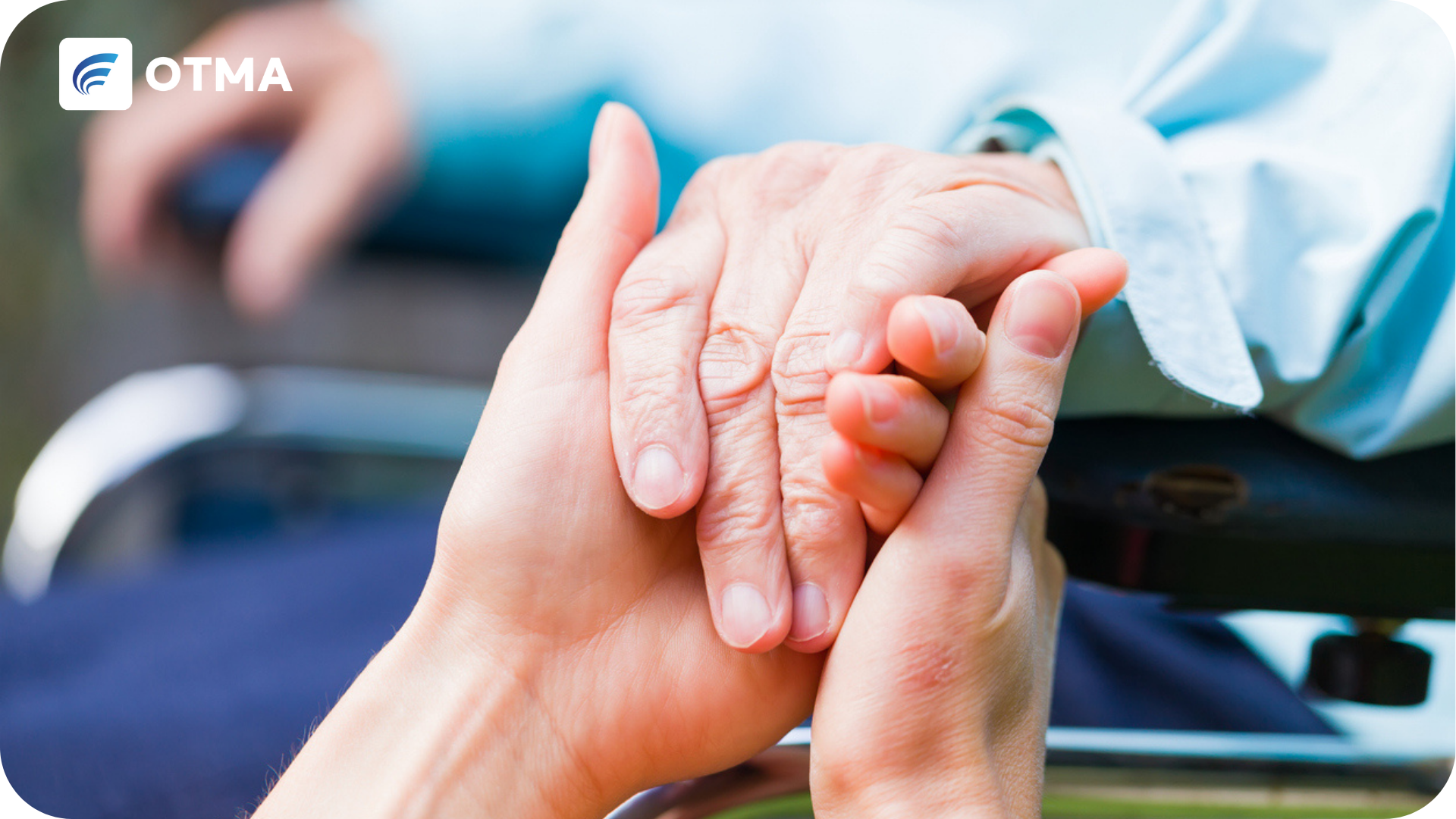 Social Work Skills represented by a young hand holding an older persons hand in a wheelchair